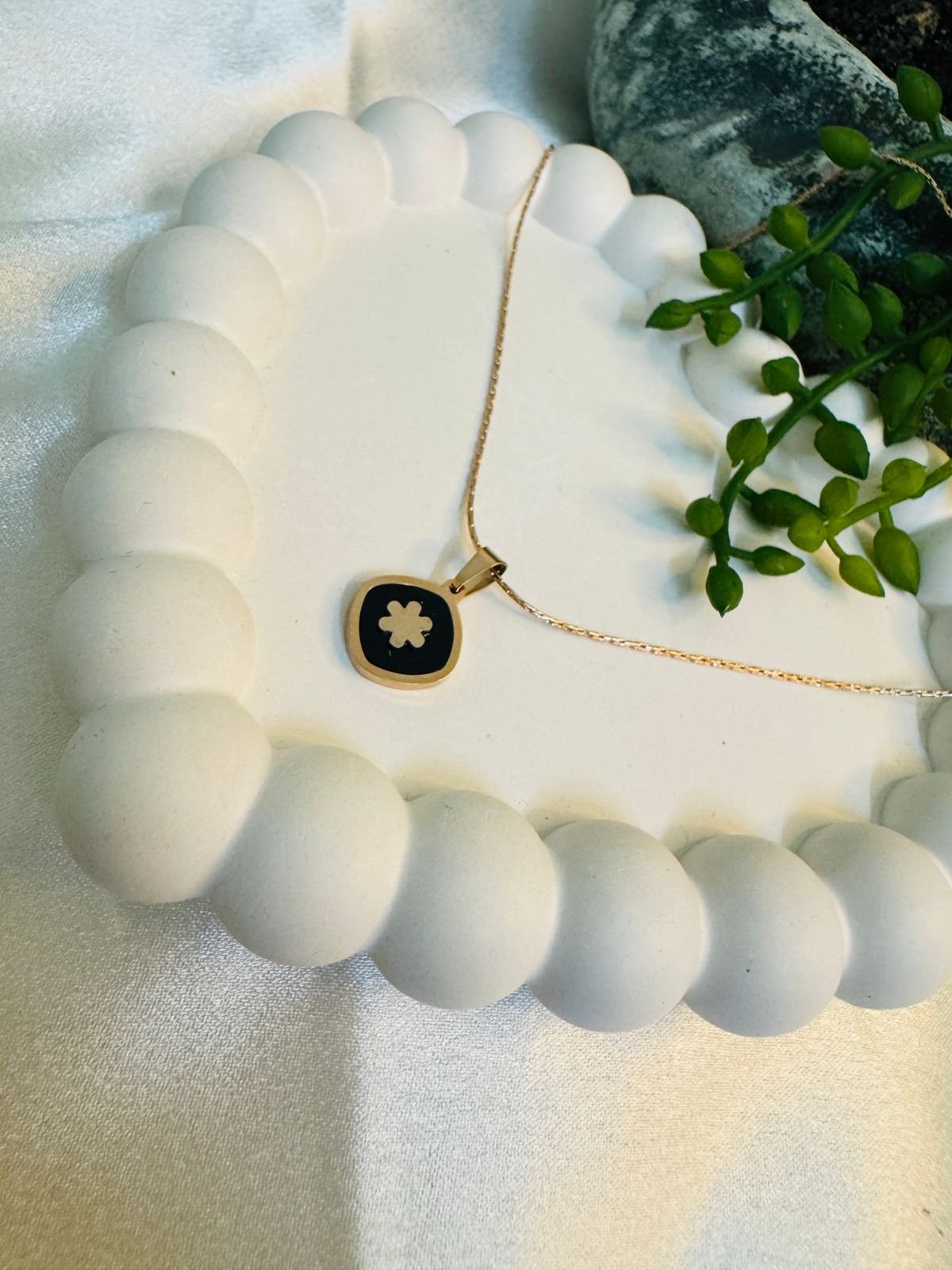 Rose gold-plated chain with a black and white clover pendant.