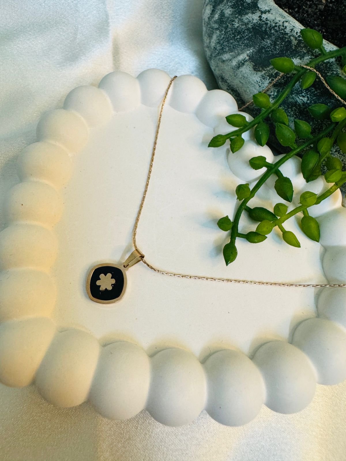 Rose gold-plated chain with a black and white clover pendant. - Image 2