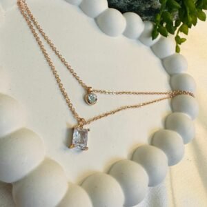 rose-gold-toned-layered-necklace-with-a-baguette-cut-and-a-round-cut-pendant