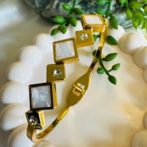 Gold-toned and white bangle-style bracelet made from stainless steel and studded with American diamonds or zircons.