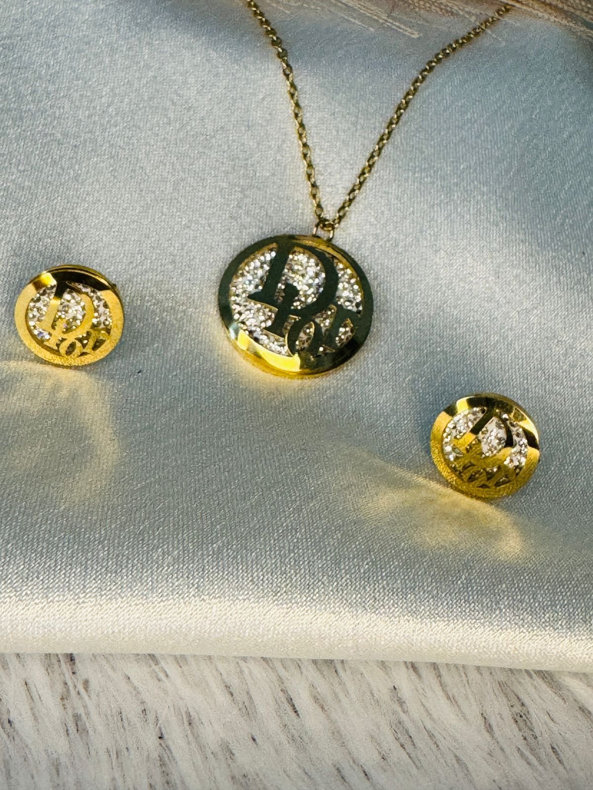 Gold-toned initial pendant necklace and matching stud earrings set with crystal embellishments. - Image 2