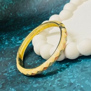 Gold-plated bangle featuring a multi-colored enamel rhombus, or checkered, pattern.
