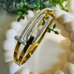 Gold-toned and white bangle-style bracelet made from stainless steel and studded with American diamonds or zircons.