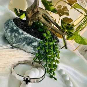 silver-colored-cuff-bracelet-with-a-black-four-leaf-clover