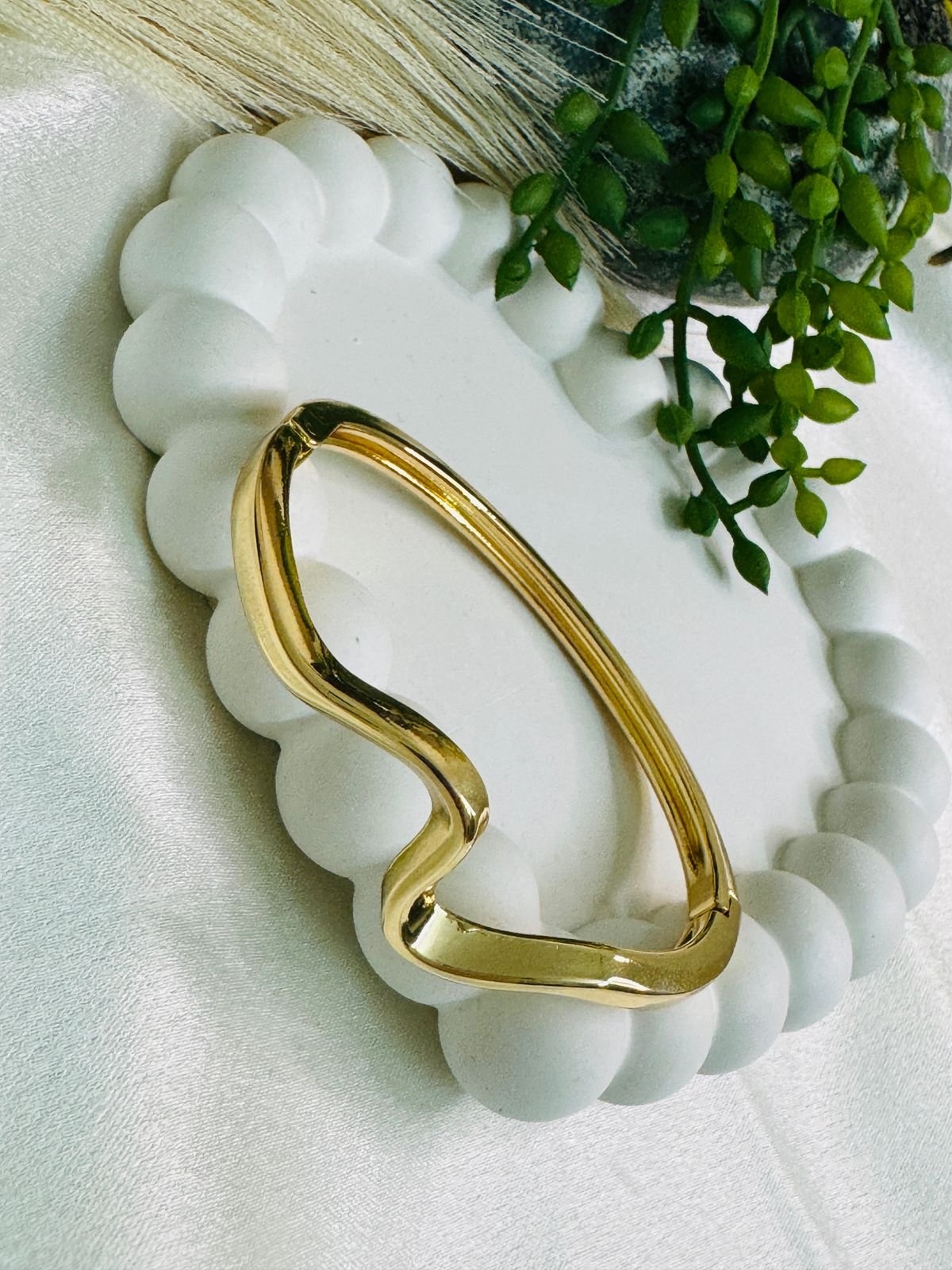 Gold-toned, wavy cuff bracelet.